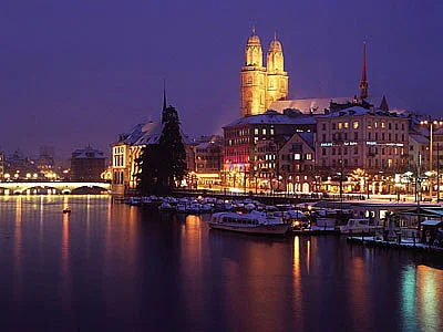 Zürich bei Nacht: beleuchtete Altstadt und Grossmünster am Wasser