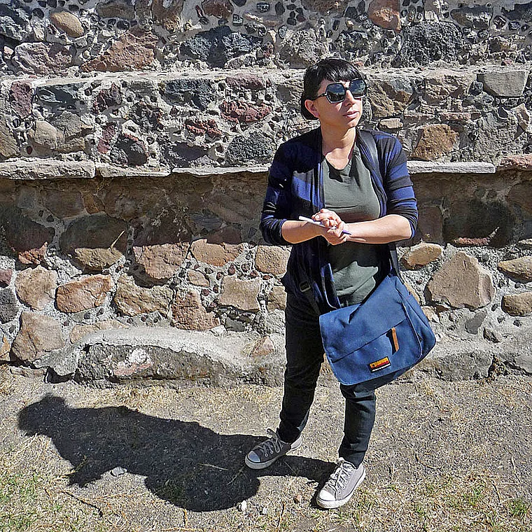 Besucherin an einer Ruinenmauer in Mexiko