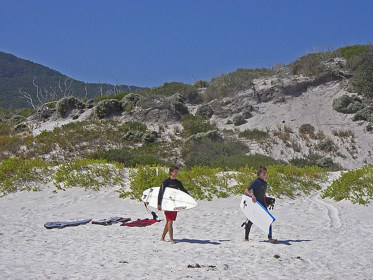 Australien Wilsons Prom Squeaky Beach Surfer mit Brett unterm Arm