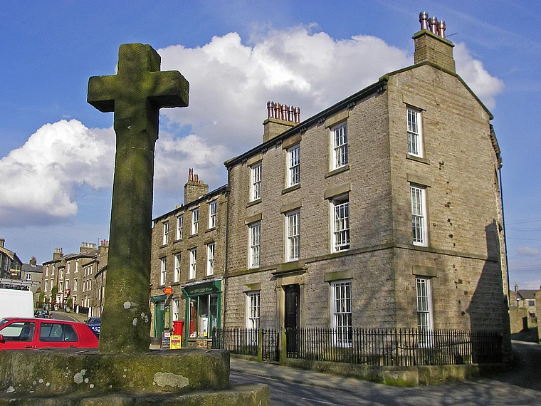 Marktkreuz und Steinhäuser in einem Dorf in Yorkshire