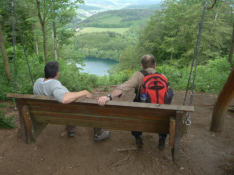 Vulkaneifel Daun Gemündener Maar von oben Wanderer auf Bank