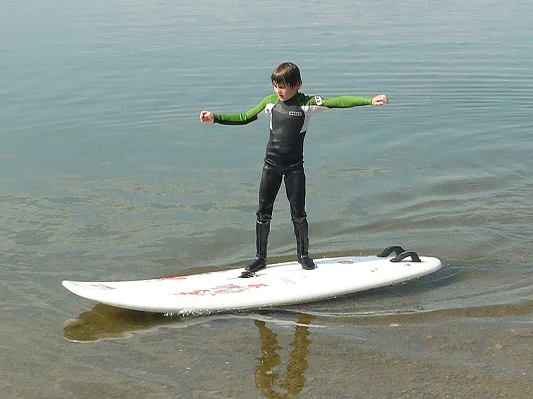 Bernau Chiemsee junger Surfer in Neoprenanzug