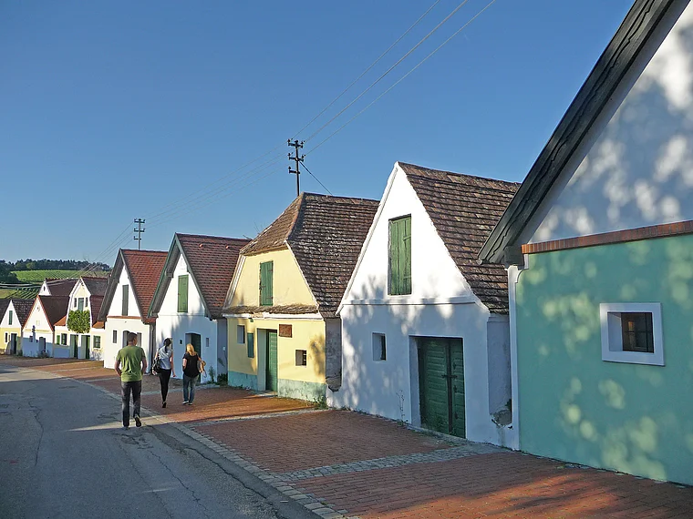 Bunte Presshäuser entlang einer Kellergasse im Weinviertel