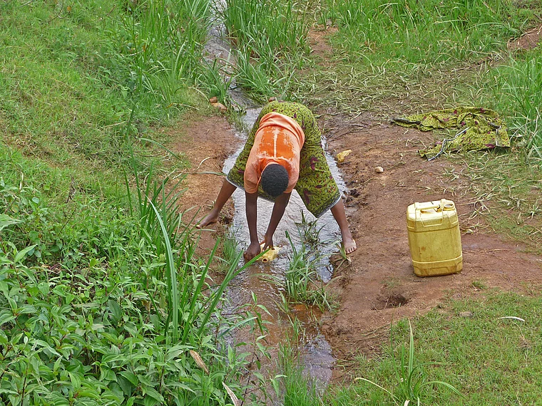 Ruanda Frau holt Wasser aus Bach