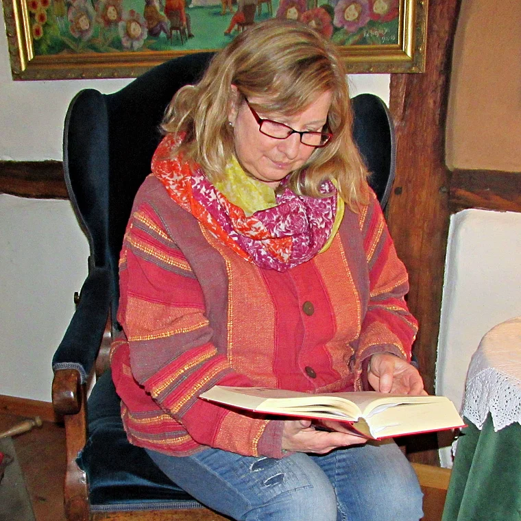Märchenerzählerin Silvia Völker liest in einem Sessel aus einem Buch