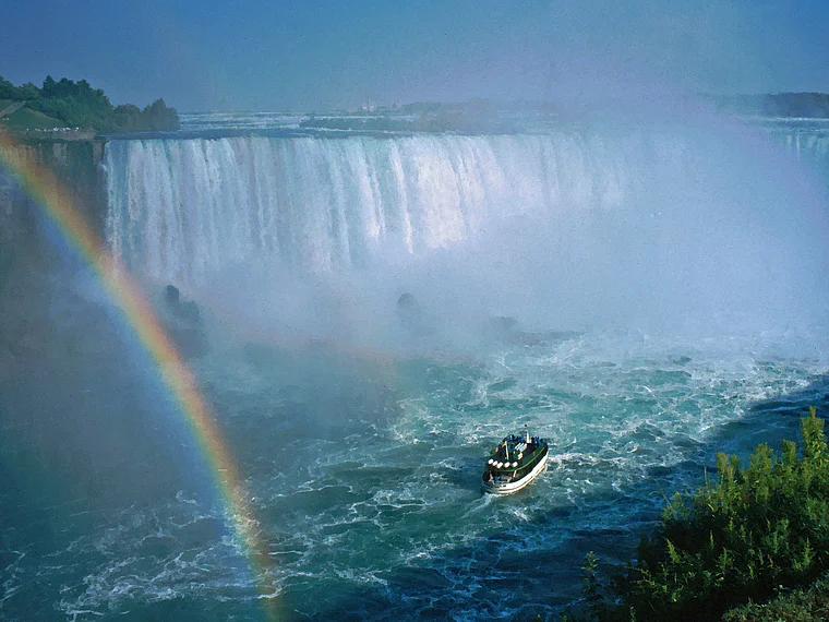 Die Niagarafälle mit Regenbogen und einem Ausflugsboot